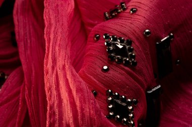 İpek desenli, kırmızı kumaş ve dekoratif yüzlü taşlar. parlak renkli taşlarla dokuma arkaplanı, doku arkaplan tasarımı