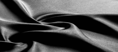 Siyah ipek kumaş. Panoramik fotoğraf. Atlas güzel ve asil bir ipek kumaştır. Işıldayan bir parıltısı, dokusu, arkaplanı, deseni var..