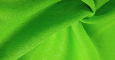 Yeşil ipek kumaş. İnce taneli Grunge yüzey dokusu, yeşil saten doku, zümrüt kumaş, ipek panorama, güzel, yumuşak doğal bulanık desenli.
