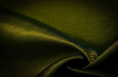 Koyu sarı kumaş, ipek kumaş, kalın dokuma, fotoğraf stüdyosu. Amber, zeytin rengi, ışık ve gölge oyunu bu fotoğrafı eşsiz kılıyor. doku, arkaplan, desen, desen