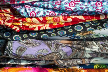 Doku arka planı, desen. Bir yığın halinde bir masaya yığılmış farklı kumaşlar