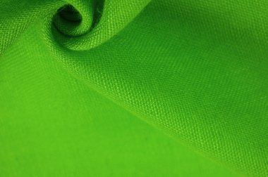 Yeşil ipek doku, yeşil ince tahıl kumaşı. Masaüstü ürünü, görüntü perspektifi, stüdyo fotoğrafçılığı. ürün demo afişi.