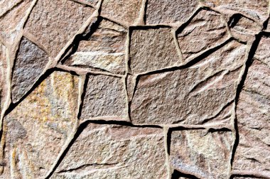 Doku arkaplan modeli. Granit taş, kumtaşı. Bina çitlerinin, kum veya kuvars taneciklerinden oluşan tortulu kayaların bitirilmesi tipik olarak kırmızı, sarı ya da kahverengi renklerde bir araya getirilir.