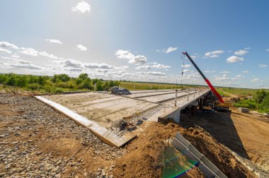 Mühendislik yapılarının fotoğrafı. Nehir üzerinde bir yol köprüsü inşaatı