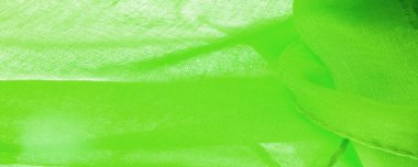 Yeşil ipek doku, yeşil ince tahıl kumaşı. Masaüstü ürünü, görüntü perspektifi, stüdyo fotoğrafçılığı. ürün demo afişi.