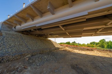 Mühendislik yapılarının fotoğrafı. Nehir üzerinde bir yol köprüsü inşaatı