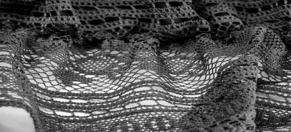 Background, texture, pattern, black lace fabric, thin open fabric, usually made of cotton or silk, made using loops, twisting or knitting threads in patterns