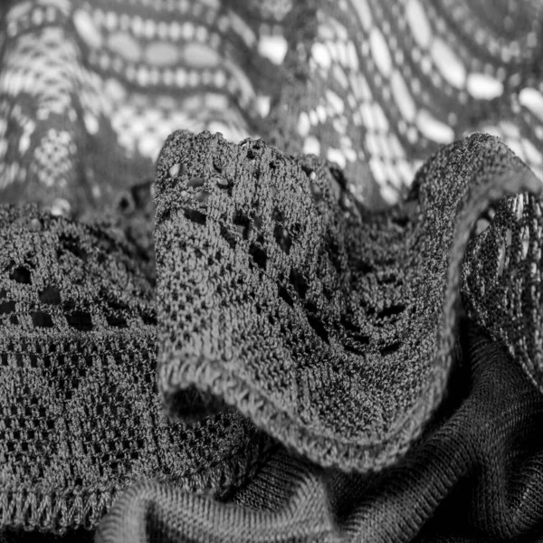 Background, texture, pattern, black lace fabric, thin open fabric, usually made of cotton or silk, made using loops, twisting or knitting threads in patterns