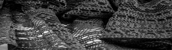 Background, texture, pattern, black lace fabric, thin open fabric, usually made of cotton or silk, made using loops, twisting or knitting threads in patterns