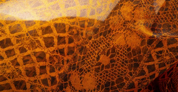 Texture, background, pattern. Gold lace, a combination of yellow gold with black fabric. red, ocher, king of metals, ochre