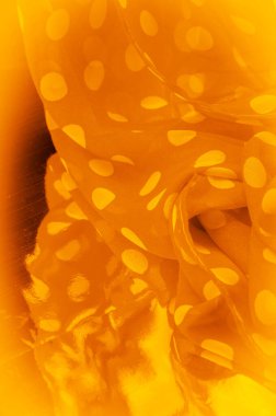 Puantiyeli sarı ipek kumaş, kumaşın üzerindeki dairesel noktalar ya da daireye benziyor. Arkaplan dokusu, dekoratif süs