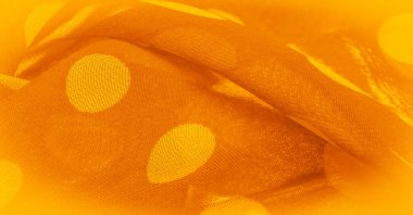 Puantiyeli sarı ipek kumaş, kumaşın üzerindeki dairesel noktalar ya da daireye benziyor. Arkaplan dokusu, dekoratif süs