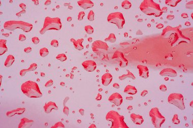 Yaz yağmuru, araba boyasının üzerine bir damla su. Sıvının küçük yuvarlak ya da armut şeklinde bir kısmı bir yüzeye tutunur ya da düşer..