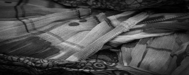 Siyah ipek kumaş, çiçek desenli. Dalgalı kıvrımlar. Kumaşın yüzeyinde ince bir dalga var. Arkaplan dokusu, dekoratif süs