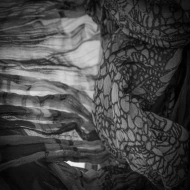 Siyah ipek kumaş, çiçek desenli. Dalgalı kıvrımlar. Kumaşın yüzeyinde ince bir dalga var. Arkaplan dokusu, dekoratif süs