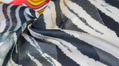 İpek kumaş, siyah-kırmızı ve beyaz çizgiler, Afrika teması, kumaş üzerindeki baskı, neşeli desen projeyi süsleyecek. Özgürlük temasının ikilemi, hayallerin gerçekliği. Desen deseni