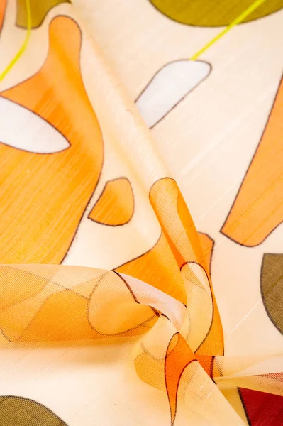 İnce örülmüş kumaş, şeffaf, kırmızı, beyaz ve sarı geometrik renkler, ince yapışkan ipekten yapılmış. Organza deseni. Doku. Arkaplan