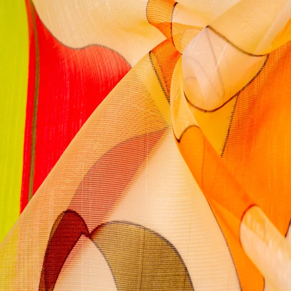 İnce örülmüş kumaş, şeffaf, kırmızı, beyaz ve sarı geometrik renkler, ince yapışkan ipekten yapılmış. Organza deseni. Doku. Arkaplan