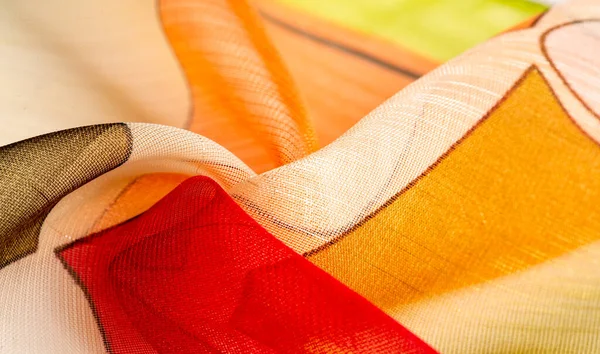 İnce örülmüş kumaş, şeffaf, kırmızı, beyaz ve sarı geometrik renkler, ince yapışkan ipekten yapılmış. Organza deseni. Doku. Arkaplan