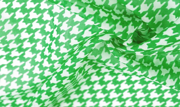 Silk fabric green pattern on a white background. A pattern on the fabric of a famous French fashion designer. Texture, background, pattern,