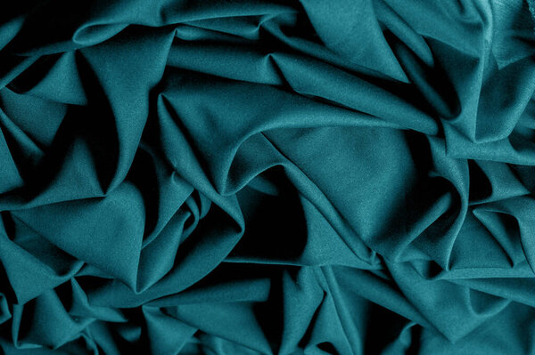 Textured, background, pattern, turquoise fabric. This is an unusual fabric that has an elegant appearance with a rich and coarse texture. It is tightly knit with designs built into the fabric itself