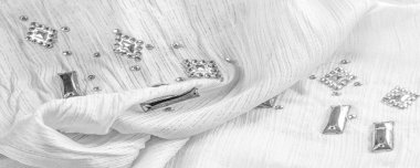 İpek desenli, beyaz kumaşlı, dekoratif yüzlü taşlar. parlak renkli taşlarla dokuma arkaplanı, doku arkaplan tasarımı