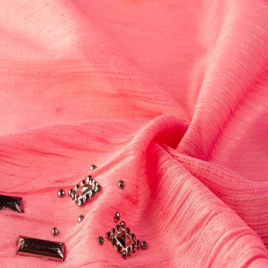 İpek desenli, kırmızı kumaş ve dekoratif yüzlü taşlar. parlak renkli taşlarla dokuma arkaplanı