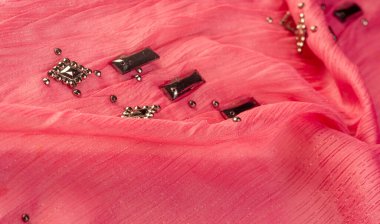 İpek desenli, kırmızı kumaş ve dekoratif yüzlü taşlar. parlak renkli taşlarla dokuma arkaplanı, doku arkaplan tasarımı