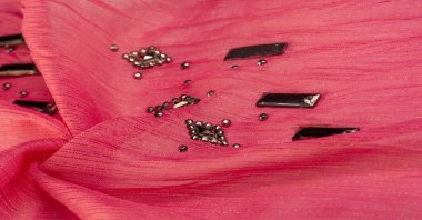 İpek desenli, kırmızı kumaş ve dekoratif yüzlü taşlar. parlak renkli taşlarla dokuma arkaplanı, doku arkaplan tasarımı