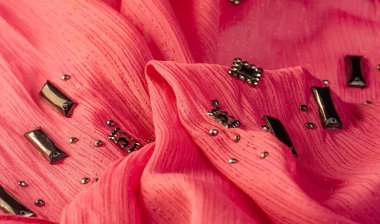 İpek desenli, kırmızı kumaş ve dekoratif yüzlü taşlar. parlak renkli taşlarla dokuma arkaplanı, doku arkaplan tasarımı