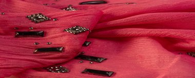 İpek desenli, kırmızı kumaş ve dekoratif yüzlü taşlar. parlak renkli taşlarla dokuma arkaplanı, doku arkaplan tasarımı