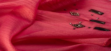 İpek desenli, kırmızı kumaş ve dekoratif yüzlü taşlar. parlak renkli taşlarla dokuma arkaplanı, doku arkaplan tasarımı