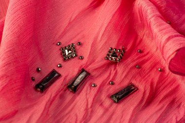 İpek desenli, kırmızı kumaş ve dekoratif yüzlü taşlar. parlak renkli taşlarla dokuma arkaplanı, doku arkaplan tasarımı