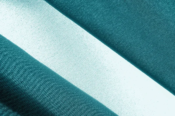 Textured, background, pattern, turquoise fabric. This is an unusual fabric that has an elegant appearance with a rich and coarse texture. It is tightly knit with designs built into the fabric itself