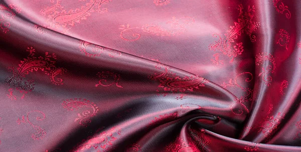 Doku, kumaş, desenli kırmızı ipek. Bu güzel baskılı ipek Charmeuse 'un deseni kalın desenli. Vatansever görünümde kırmızı renkler var, kumaşın kaygan bir eli var.