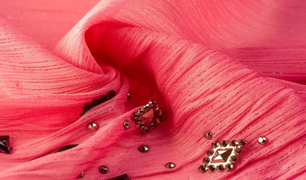 Arkaplan tasarımı dokusu, ipek desen, pembe kumaş ve dekoratif işlemeli taşlar.