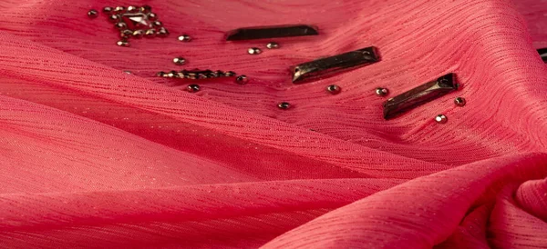 Arkaplan tasarımı dokusu, ipek desen, pembe kumaş ve dekoratif işlemeli taşlar.