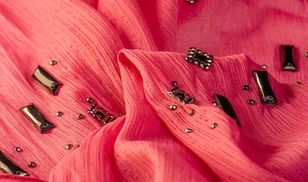 İpek desenli, kırmızı kumaş ve dekoratif yüzlü taşlar. parlak renkli taşlarla dokuma arkaplanı, doku arkaplan tasarımı