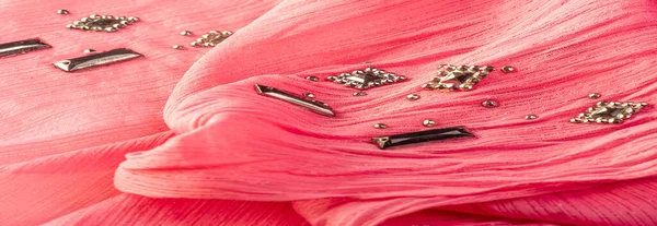 İpek desenli, kırmızı kumaş ve dekoratif yüzlü taşlar. parlak renkli taşlarla dokuma arkaplanı, doku arkaplan tasarımı