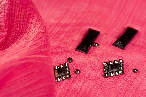 İpek desenli, kırmızı kumaş ve dekoratif yüzlü taşlar. parlak renkli taşlarla dokuma arkaplanı, doku arkaplan tasarımı