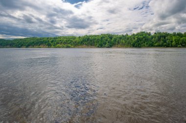 Nehir manzarası, yeşillik ve bulutlu gökyüzü