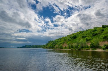 Nehir manzarası, yeşillik ve bulutlu gökyüzü