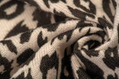 Doku, arkaplan, desen, kadın yün şalı, siyah ve bej, Afrika motifleri, yün ve modülden yapılmış, kenarları kıvrımlı bir yılan şeklinde..