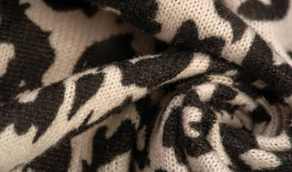 Doku, arkaplan, desen, kadın yün şalı, siyah ve bej, Afrika motifleri, yün ve modülden yapılmış, kenarları kıvrımlı bir yılan şeklinde..