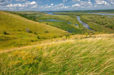 Nehir manzarası, yeşillik ve bulutlu gökyüzü