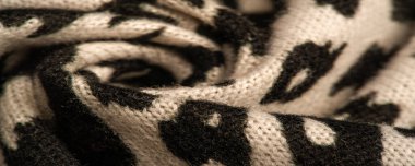 Doku, arkaplan, desen, kadın yün şalı, siyah ve bej, Afrika motifleri, yün ve modülden yapılmış, kenarları kıvrımlı bir yılan şeklinde..