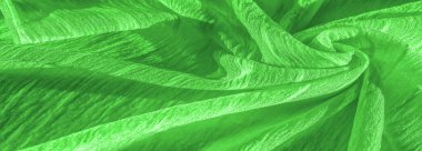 İpek kumaş. Yeşil kırışık kumaş dokusu. Yeşil buruşuk, dalgalı yüzey dokusu. Yakın çekim, yumuşak odaklanma. arkaplan, kalıp