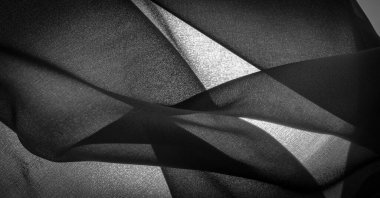 Koyu siyah şifon ipeği, bükülmüş iplik kullanımı nedeniyle hafif pürüzlü (matte, creped) yumuşak şeffaf bir kumaştır. Arkaplan dokusu