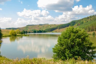 Nehir manzarası, yeşillik ve bulutlu gökyüzü