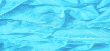 İpek kumaş. Mavi buruşuk kumaş dokusu. Mavi buruşuk, dalgalı yüzey dokusu. Yakın çekim, yumuşak odaklanma. arkaplan, kalıp